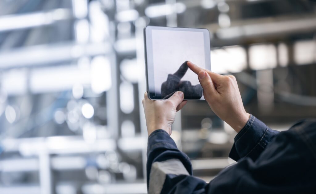 Person using a tablet to analyze real-time data in a food manufacturing or supply chain environment