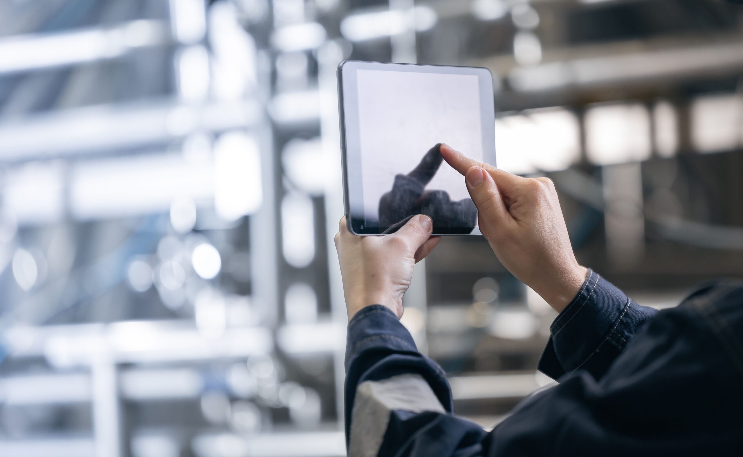 Person using a tablet to analyze real-time data in a food manufacturing or supply chain environment
