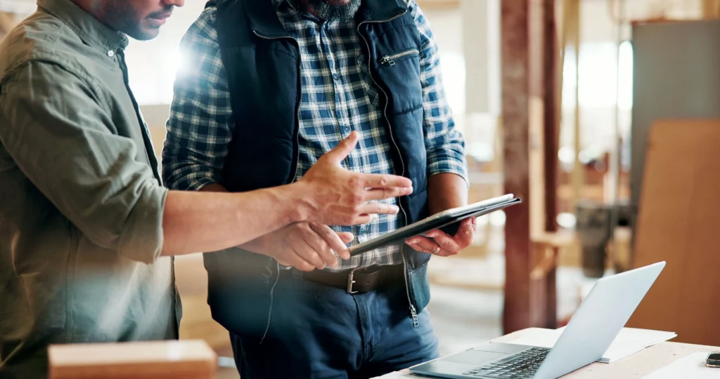 Foodservice professionals reviewing purchasing data on a tablet and laptop